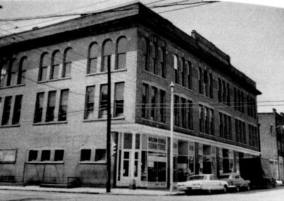 Black-and-white street-level photograph of a multi-story building with large windows and arched architectural details, once home to WPTF operations.